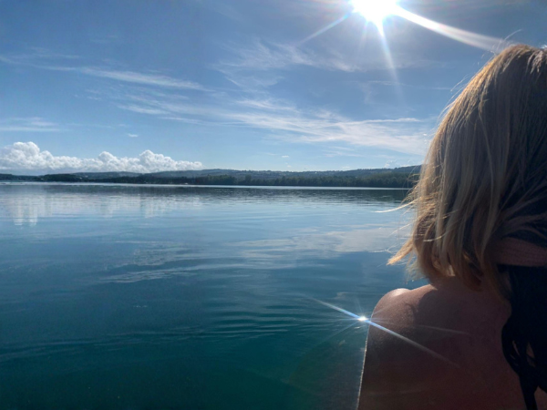 Femme contemplant un lac sous la lumière du soleil, rituel de reconnexion à soi, philosophie Maison Onera