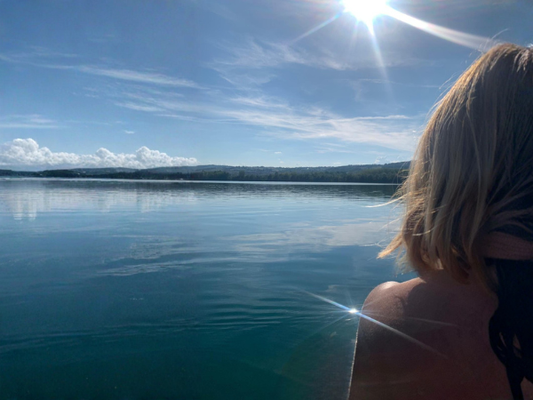 Femme contemplant un lac sous la lumière du soleil, rituel de reconnexion à soi, philosophie Maison Onera