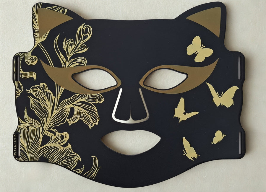 glamour Masque LED ONËRA noir et or avec détails dorés et oreilles de chat, appareil de luminothérapie visage au style glamour
