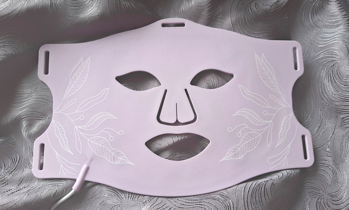 Masque LED La reveuse ONËRA rose parme avec finition douce et fleurie, appareil haut de gamme de luminothérapie visage au design féminin pour des soins peau apaisants, purifiant et raffermissants à la maison
