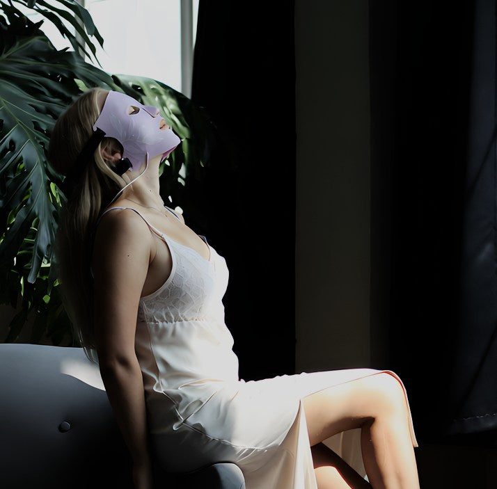 Femme portant le masque LED ONËRA la Reveuse coloris rose parme, pendant une séance de soin visage relaxante à la lumière infrarouge